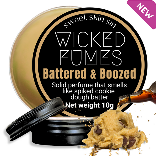 picture of tin of Wicked Fumes Battered & Boozed cookie dough perfume. with a pile of cookie dough and a whisky bottle being poured over it
